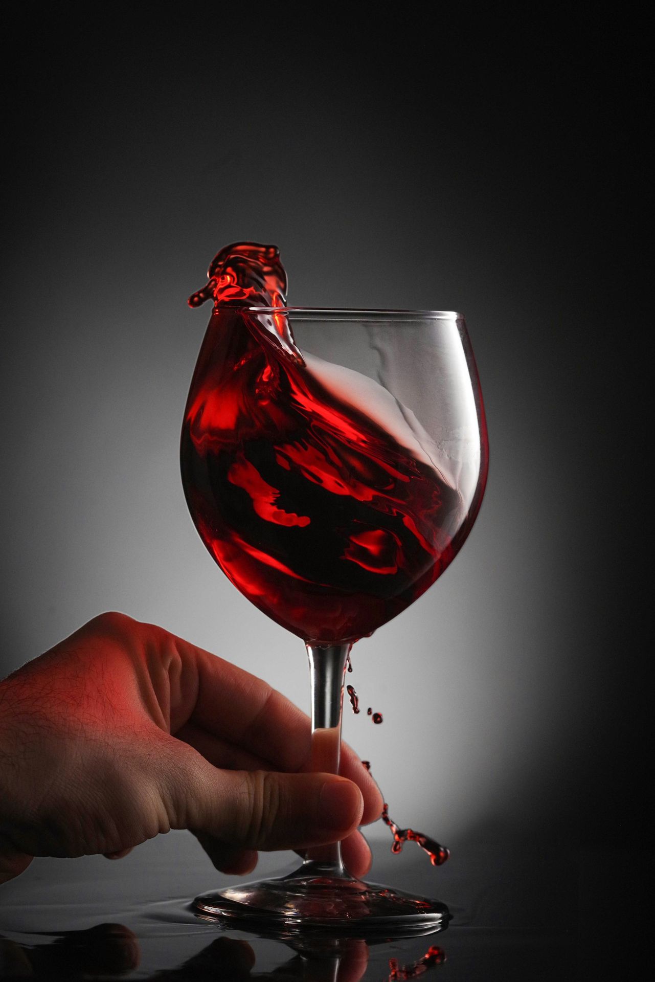 a glass of red wine being poured into it